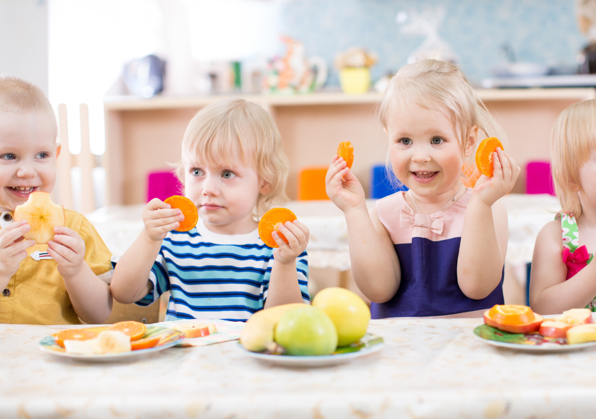 a group of children holding orange slices